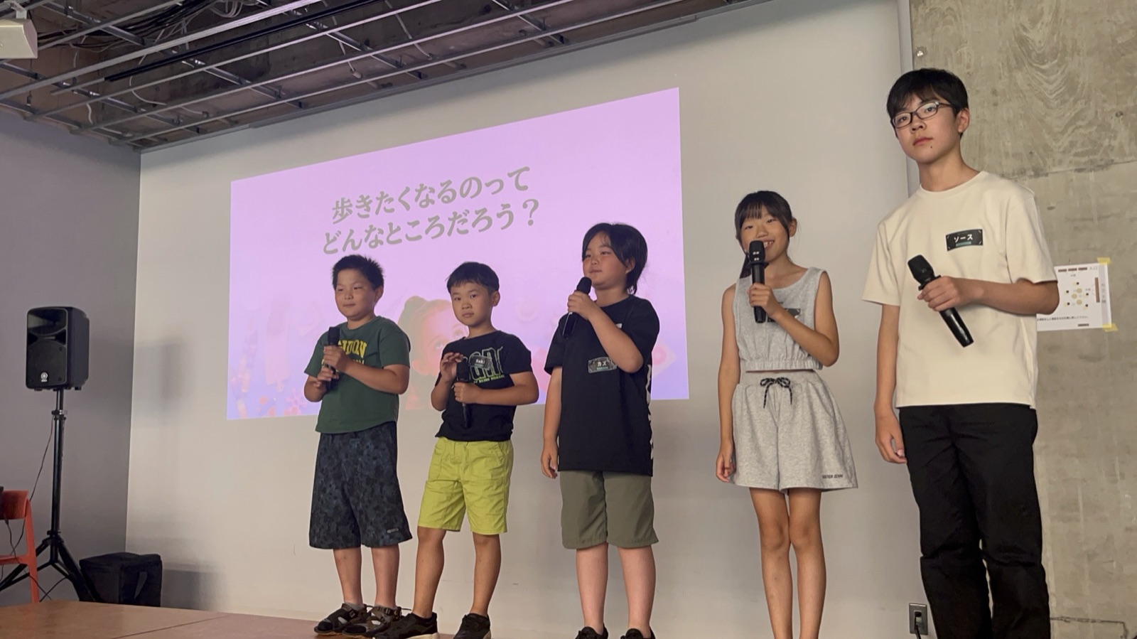 苫小牧市の発表会で、ステージに並びマイクを持って自分たちの考えを話す子どもたち